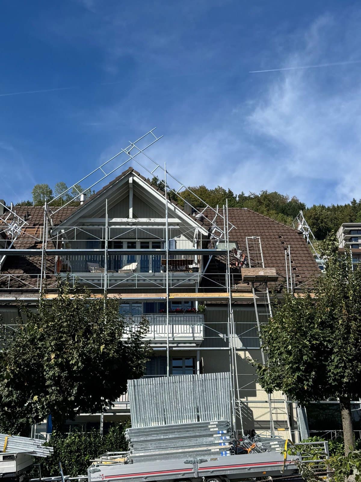 Dachfanggerüst am Giebel eines Mehrfamilienhauses – sicherer Zugang für Notabdeckung und Dachreparatur
